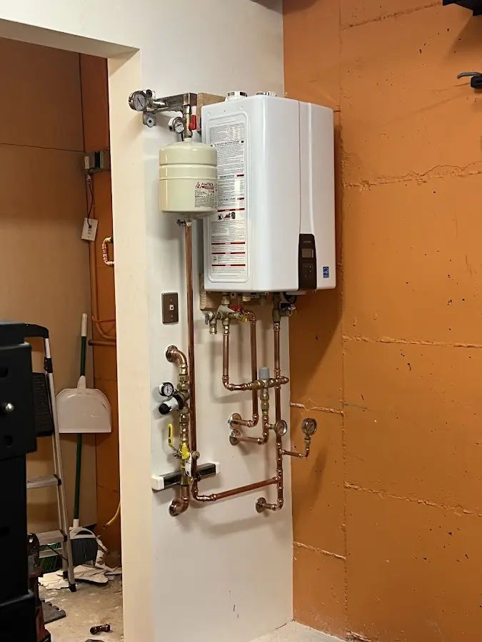 Plumbing technician inspecting water heater connections in Washington